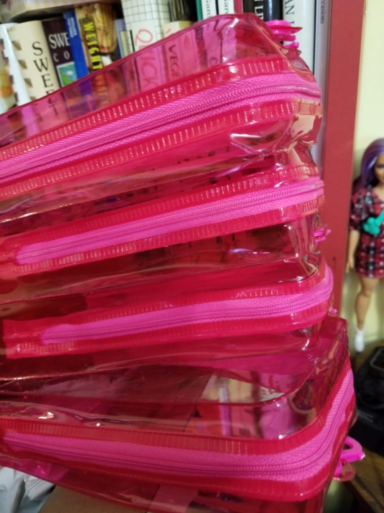 Pink plastic zipper cases that held 2021 Barbie Fashionistas