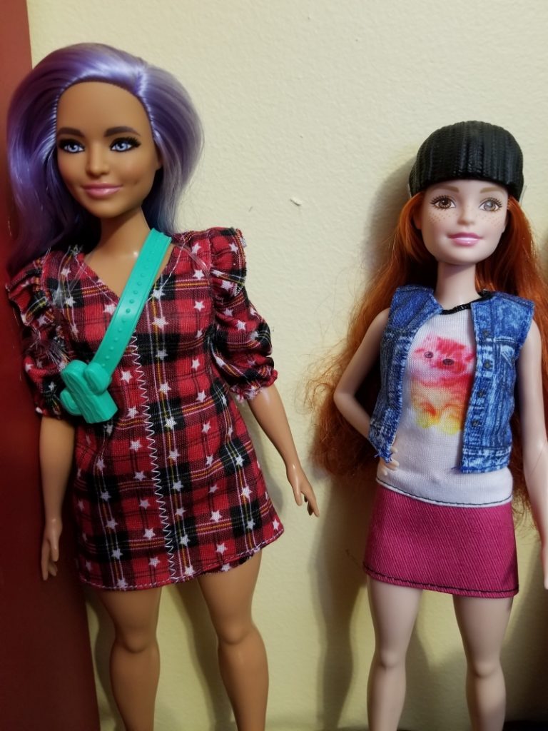 Two Barbie Fashionistas, which are 157 and one with a catprint t-shirt and freckles